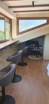 a living room with two chairs and a window at Къща за гости ОЗИ 3 in Ovchartsi
