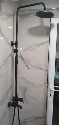 a shower with a glass door and a lamp at Къща за гости ОЗИ 3 in Ovchartsi