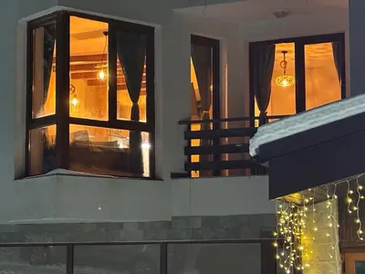 a room with two windows and a staircase with christmas lights at Alpine Apart Pamporovo in Pamporovo