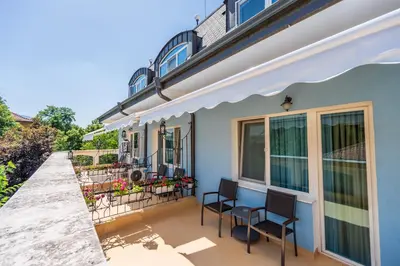 a house with two chairs and a table on a balcony at Family Hotel Lazur in Kyustendil