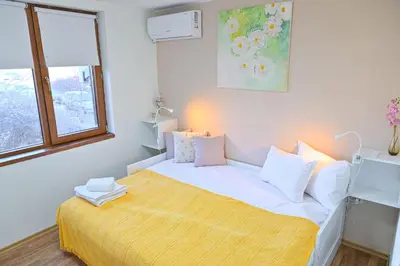 a white bedroom with a bed with a yellow blanket at Comfortable 1-Bedroom Apartments in Bansko - Close to Gondola by Flat Mаnаger in Bansko