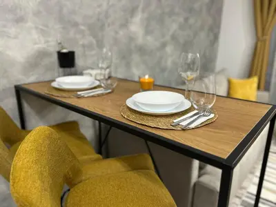 a wooden table with plates and wine glasses on it at Le Bijou МОЛ Плаза in Plovdiv