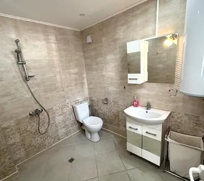 a bathroom with a toilet and a shower and a sink at Кольовата къща Тетевен in Teteven