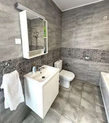 a bathroom with a white sink and a toilet at Кольовата къща Тетевен in Teteven