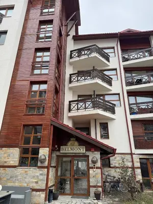 a building with a sign that reads benoit at Belmont Apartment in Bansko