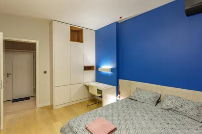 a bedroom with a blue wall and a bed and a desk at NDK - Grand View Apartment in Sofia