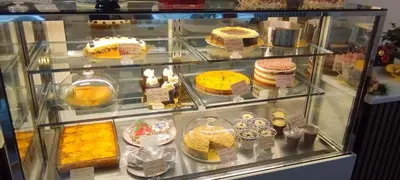 a display case filled with cakes and other desserts at PIRIN GOLF - NIRVANA new, SPA in Razlog