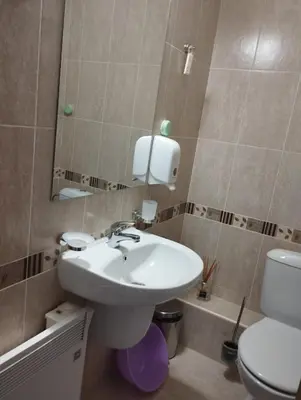 a bathroom with a sink and a toilet and a mirror at PIRIN GOLF - NIRVANA new, SPA in Razlog
