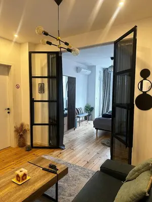 a living room with a couch and a table at Serdika Central Stay - 2BD next to Serdika Metro Station in Sofia