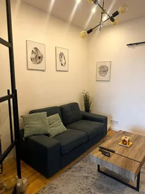 a living room with a couch and a table at Serdika Central Stay - 2BD next to Serdika Metro Station in Sofia