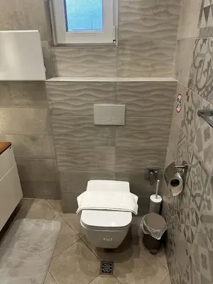a small bathroom with a toilet and a window at Serdika Central Stay - 2BD next to Serdika Metro Station in Sofia