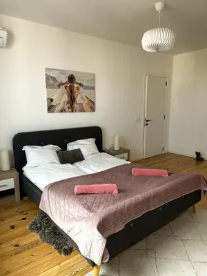 a bedroom with a large bed with pink pillows on it at Serdika Central Stay - 2BD next to Serdika Metro Station in Sofia