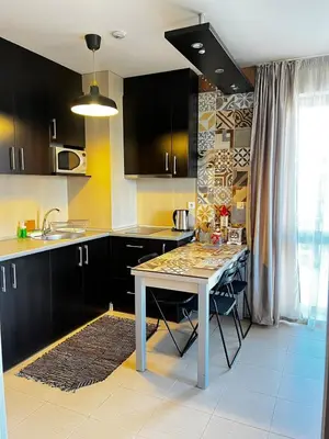 a kitchen with black cabinets and a white table at BANSKO Deluxe Apartment Belvedere - 350m SkiLift in Bansko