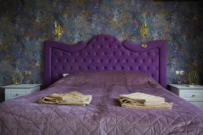 a purple bed with a purple comforter and two nightstanduments at Апартамент за гости Марица in Asenovgrad