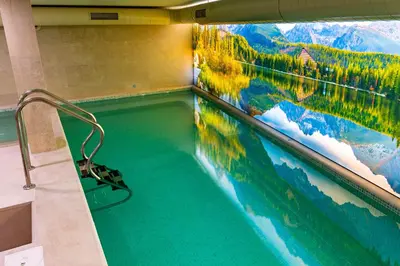 a swimming pool with a painting on the wall at Семеен хотел РАЙ in Ognyanovo