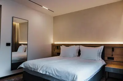 a bedroom with a large bed with a mirror at Семеен хотел РАЙ in Ognyanovo