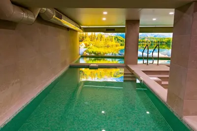 a swimming pool with a view of a river at Семеен хотел РАЙ in Ognyanovo