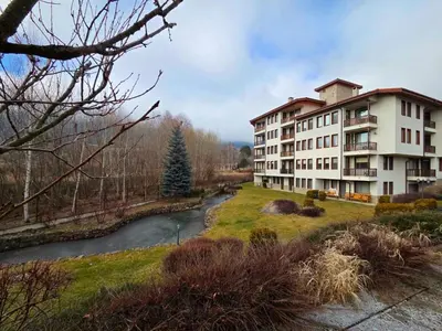 a building next to a river next to a building at Apartment Lily Complex Padaloto in Smolyan