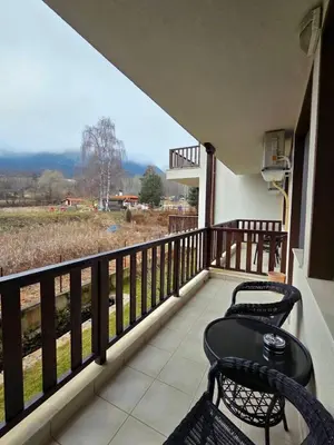 a balcony with two chairs and a table and a view at Apartment Lily Complex Padaloto in Smolyan