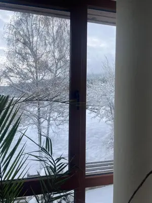 a window with a view of the snow outside at Apartment at the foot of Pirin in Bansko