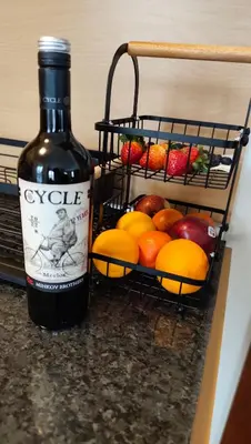 a bottle of wine next to a basket of fruit at Apartment Danik City Garden in Bansko