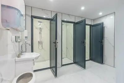 a bathroom with four shower stalls and a sink at Caravan for rent in Bansko