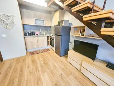 a kitchen with wooden floors and a living room at Vista Apartment in Borovets