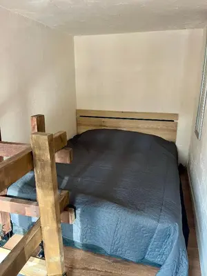 a bed in a small room with a wooden frame at The Cube in Samokov
