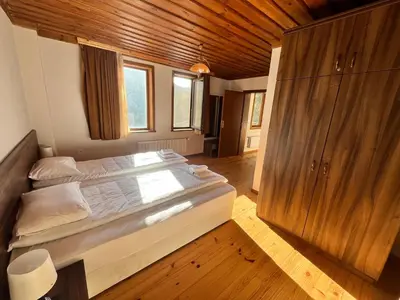 a bedroom with a large bed and a wooden ceiling at Къща за гости в село Проглед - комплекс Божидарица 4А in Progled