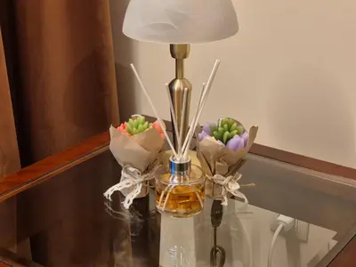a lamp on a glass table with a vase of flowers at Mountain Heaven Downtown in Bansko