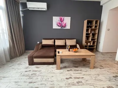 a living room with a couch and a coffee table at Апартамент Аксел in Panagyurishte