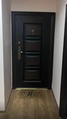 a black door with a sign in front of it at Апартамент Аксел in Panagyurishte