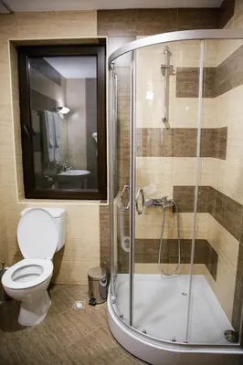 a bathroom with a shower with a toilet and a sink at Einstein House & Spa in Marchevo