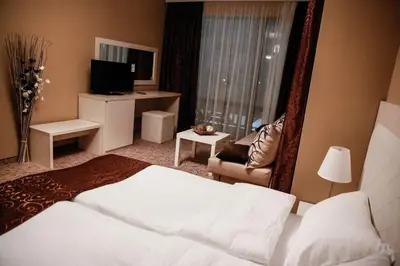 a hotel room with a large bed and a television at Einstein House & Spa in Marchevo