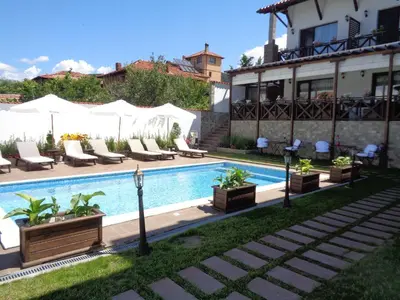 a swimming pool with lounge chairs and a building at Einstein House & Spa in Marchevo