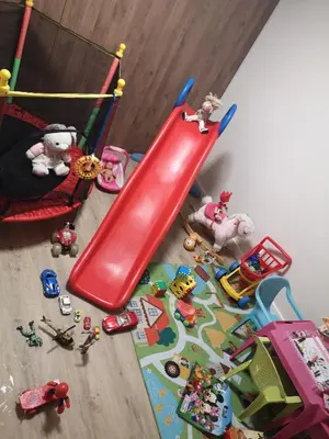 a red slide in a room with toys on the floor at Алтъна Калофер in Kalofer