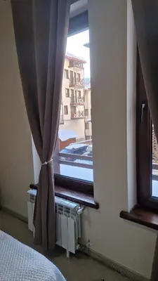 a bedroom with a window with a view of a building at Studio Kalina Green Life in Pamporovo