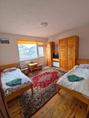 a bedroom with two beds and a rug at Guest house Belitsa in Semkovo