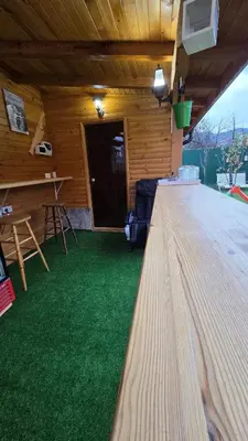 a room with a table and a green floor at Guest house Belitsa in Semkovo