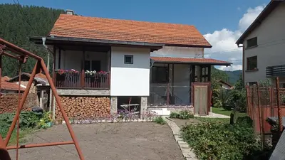 a small house with a balcony with flowers on it at Марковата Къща in Madzhare