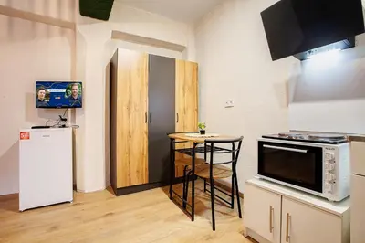a small kitchen with a small table and a refrigerator at Cozy Homes Slivnitsa Studios in Sofia