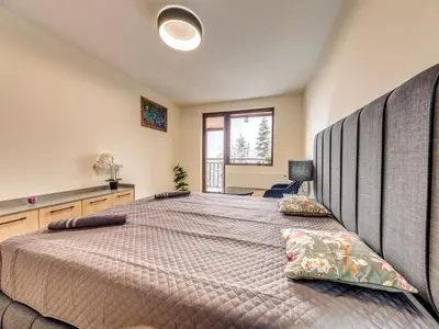a bedroom with a large bed with two pillows at 1BD Mountain Getaway in Pamporovo with Parking By Flat Mаnager in Pamporovo