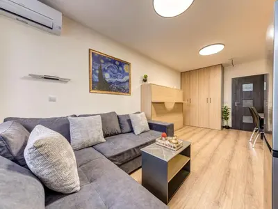 a living room with a couch and a table at Alpine Glow Studio with Parking Pamporovo in Pamporovo