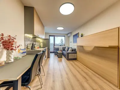 a kitchen and living room with a counter and a couch at Alpine Glow Studio with Parking Pamporovo in Pamporovo