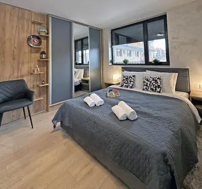 a bedroom with a large bed with two towels on it at New! Park Lane Bansko Residences in Bansko