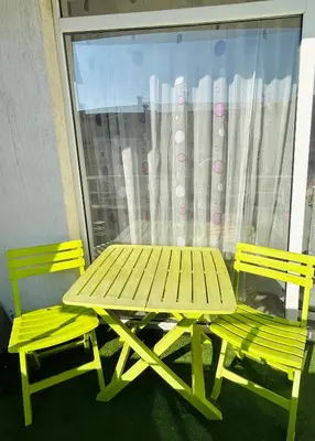 a picnic table and two chairs in front of a window at Cozy apartment kids friendly in Sofia