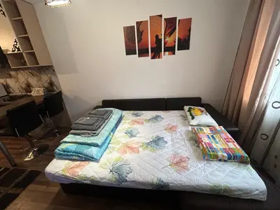 a bed with a quilt on it in a room at Cozy apartment kids friendly in Sofia