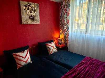 a bedroom with a bed and a red wall at Bansko Peak Apartments 116 in Bansko