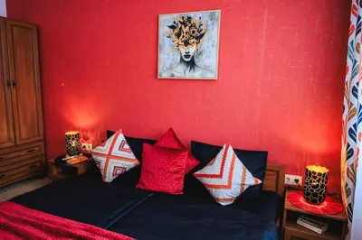 a bedroom with a red wall with a bed with pillows at Bansko Peak Apartments 116 in Bansko