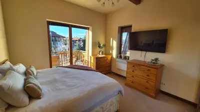 a bedroom with a large bed and a television at 3 bedroom Penthouse only 700 meters from Ski Lift in Bansko